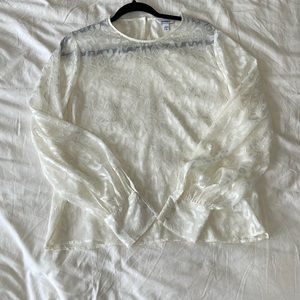 White animal print blouse, slight balloon sleeves, dainty buttons at the sleeve.